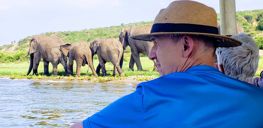 Visitors on a safari boat cruise on Kazinga Channel in Queen Elizabeth National Park, Uganda, viewing wildlife and scenic landscapes.