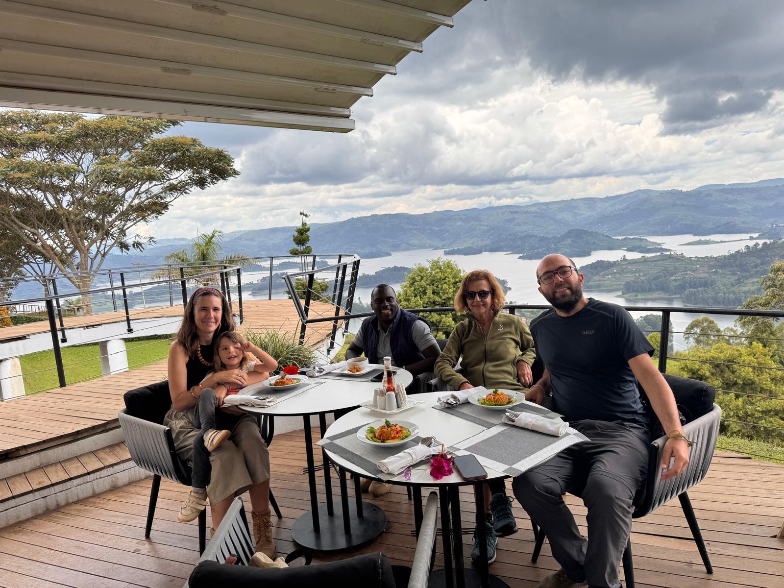 A group of guest having lunch with a background of lake Bunyonyi on Uganda Safari