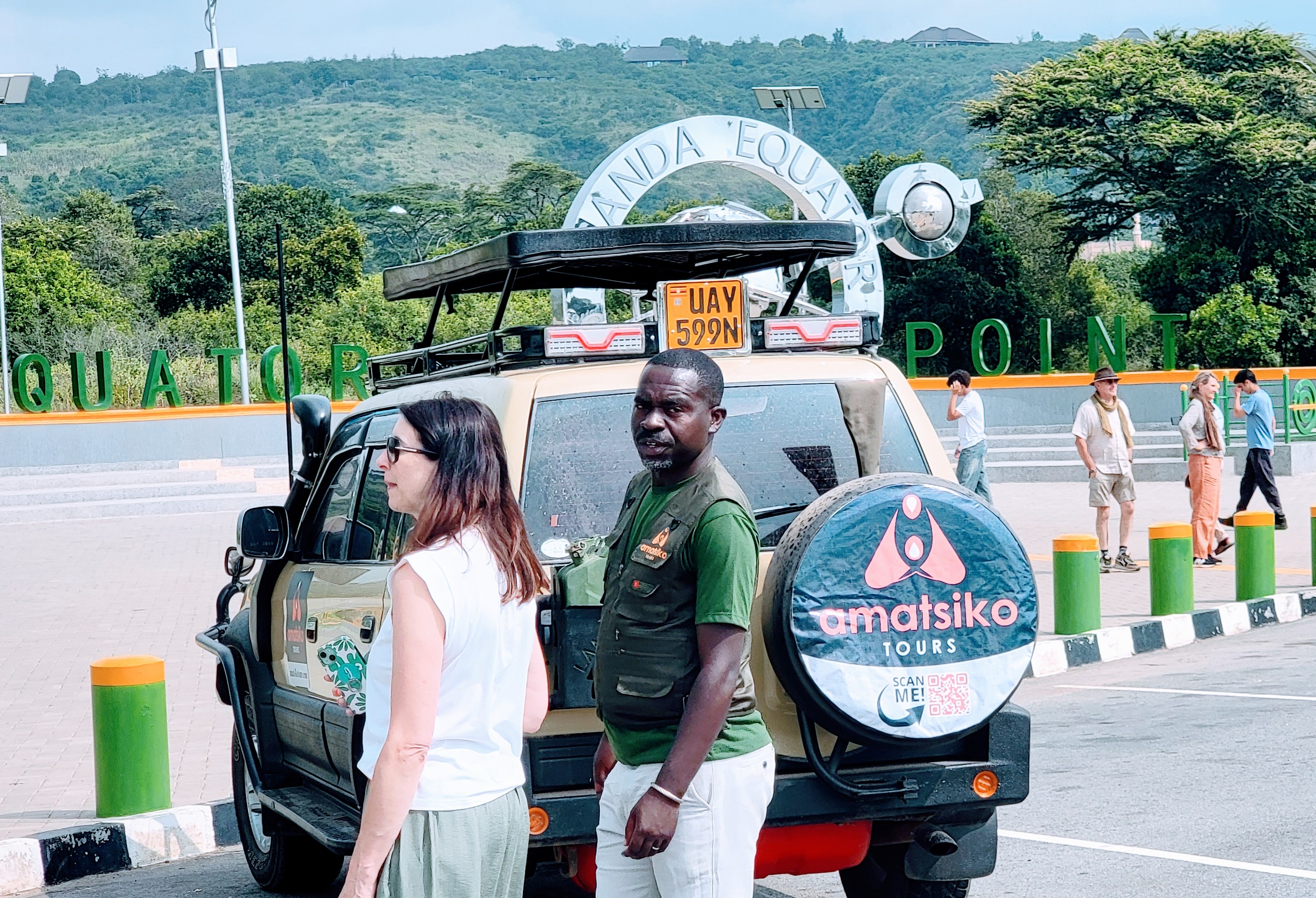 Guests posing at the Uganda Equator Monument during their Uganda safari journey.