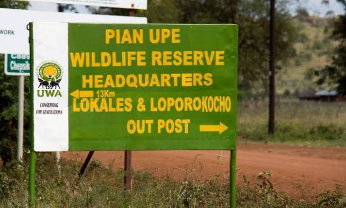 Roadside entrance sign welcoming visitors to Pian Upe Wildlife Reserve in northeastern Uganda.