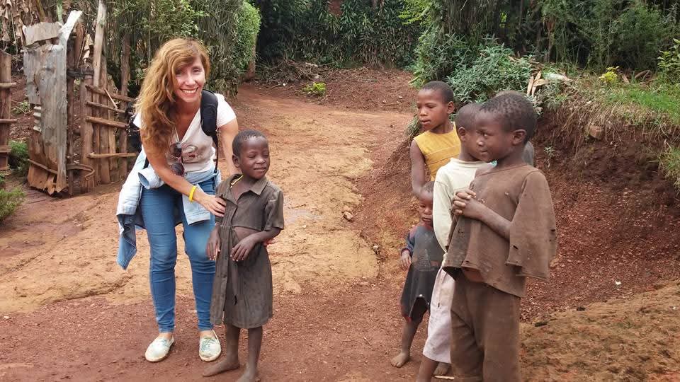 Traveler connecting with children in a Ugandan community through a responsible cultural tourism experience