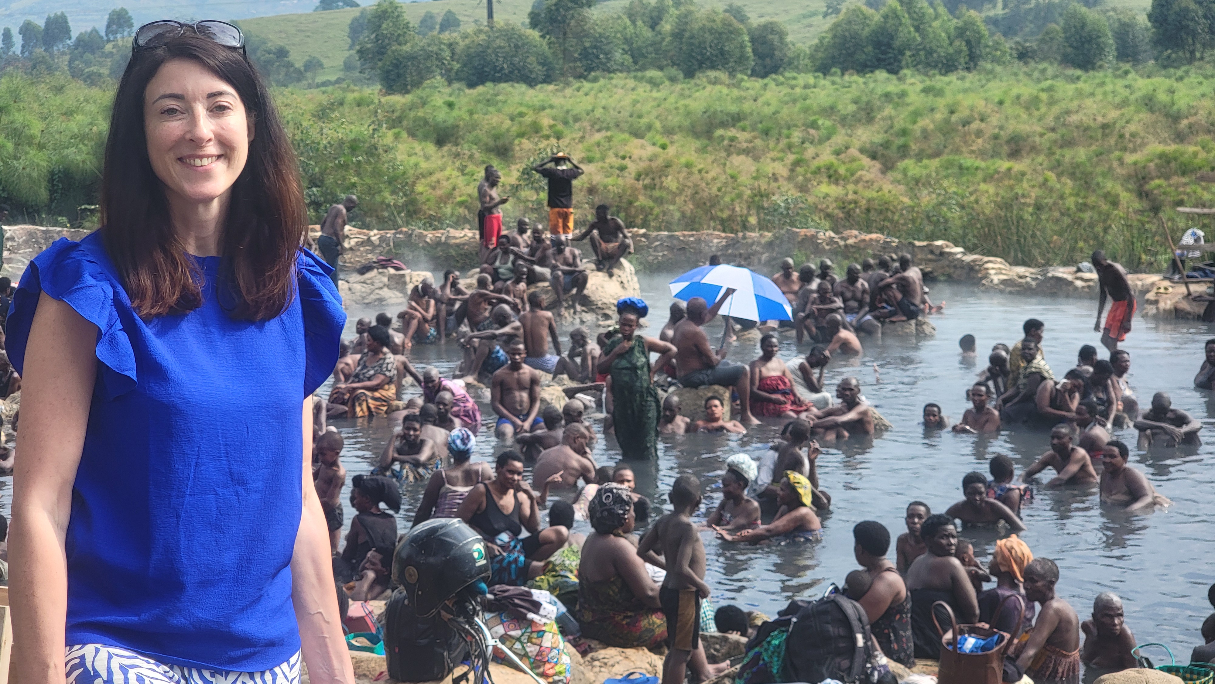 Guest posing with locals at a Ugandan hot spring