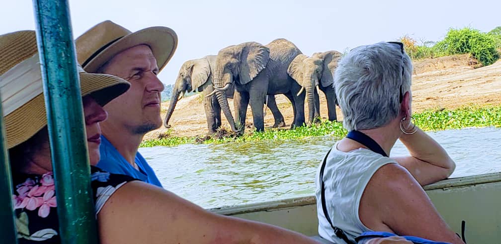 Small-group travelers on a boat safari along Uganda’s Kazinga Channel in Queen Elizabeth National Park.