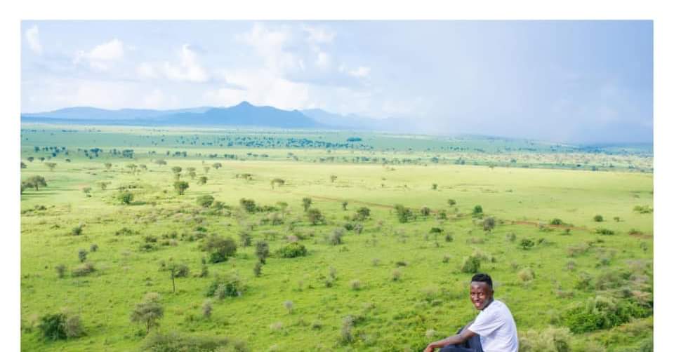 A guide overlooks the green expanse of Uganda's southwestern highlands, the kind of terrain you'll cross on safari between parks